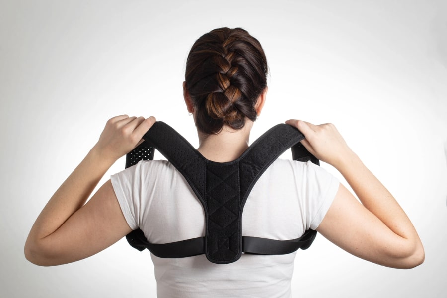 a girl in a white t shirt wears a posture corrector