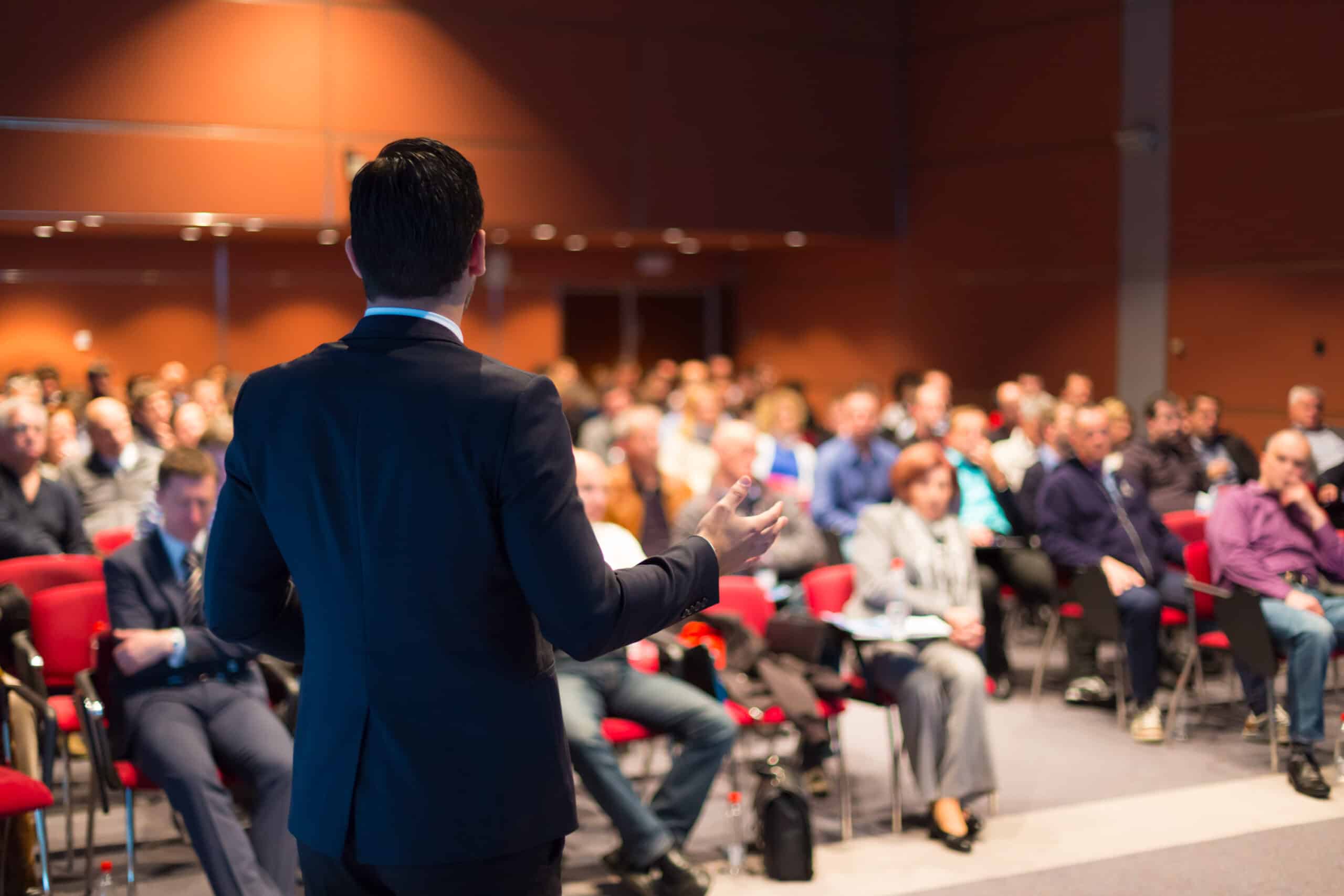 a man speaking at a business conference