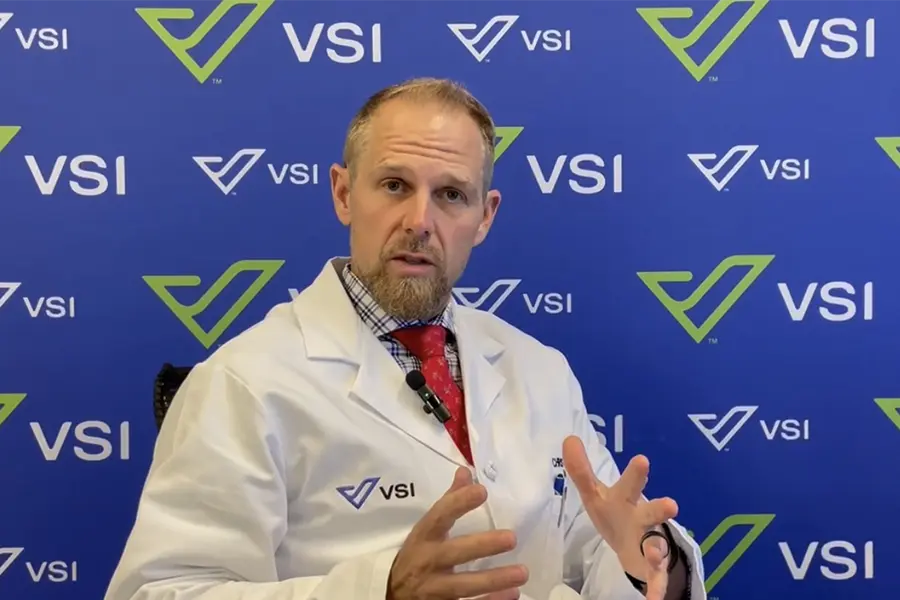 Dr. Good in white coat in front of VSI sign