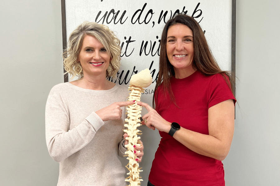 Crystal and Katie holding model of a spine