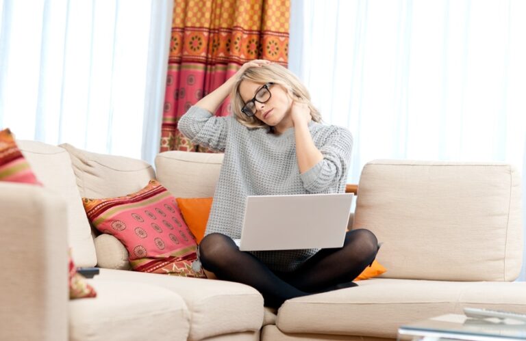 woman having neck pain while working from home