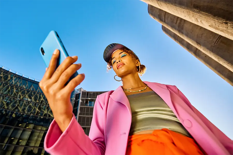 girl in pink looking down at new trend on phone
