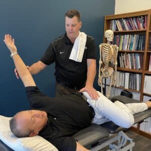 Physical therapist performs hip stretches.