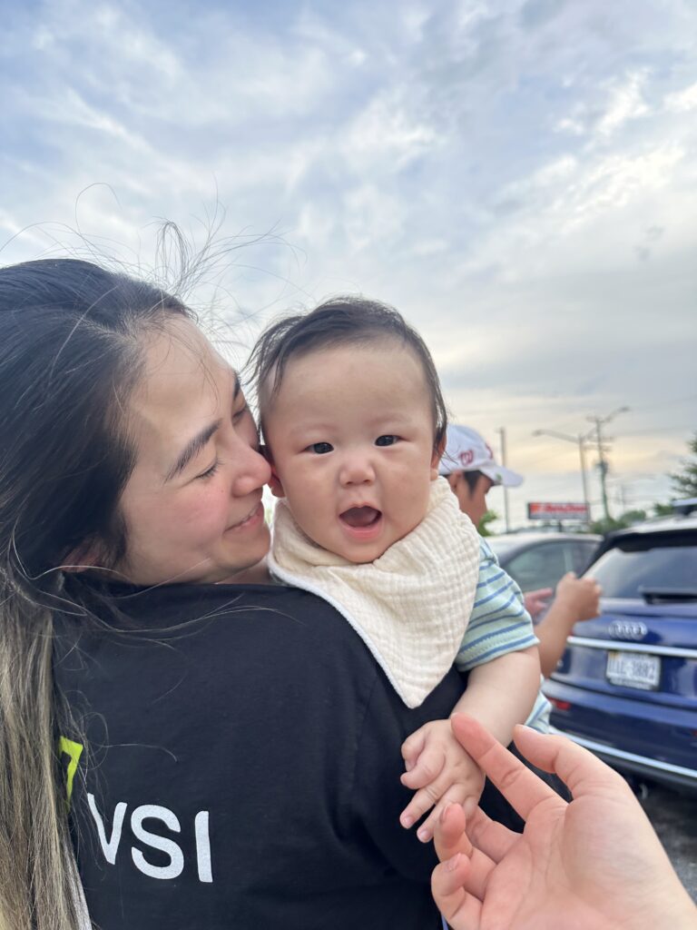 Mom holding and looking down at smiling baby
