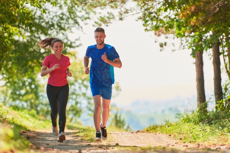 A couple running among green trees