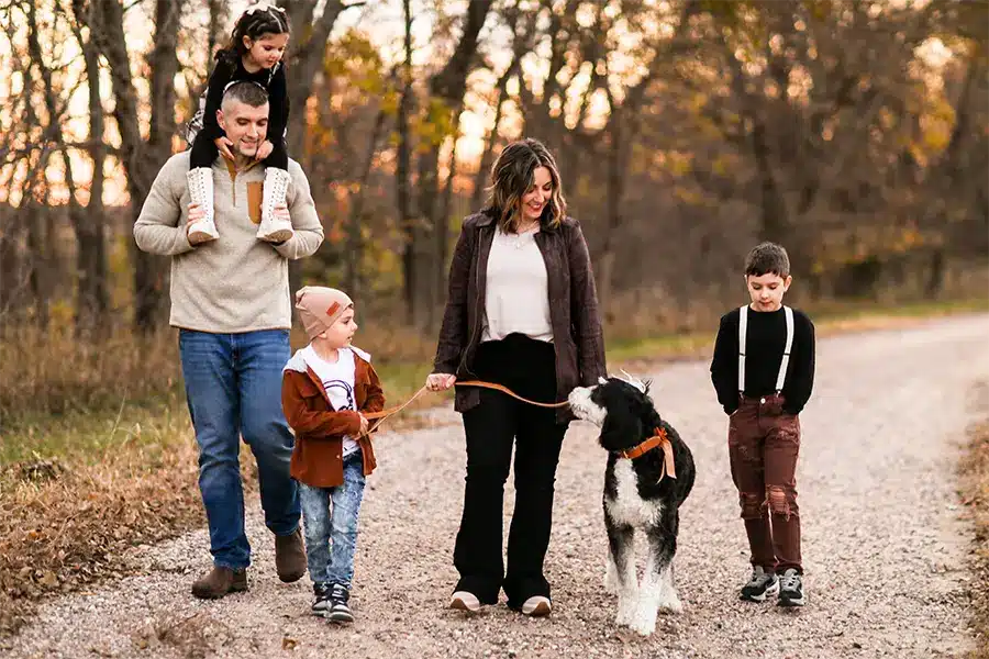 Family walking in the woods with their dog