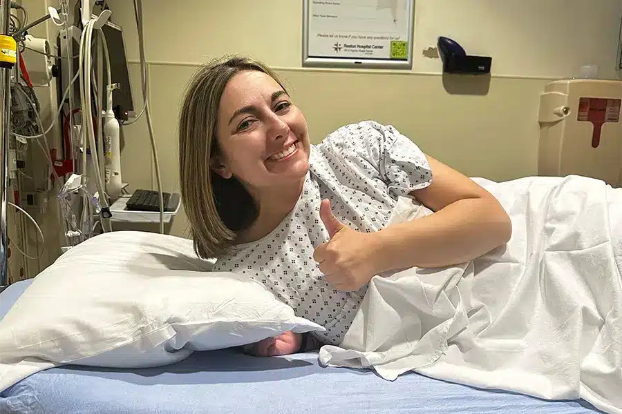 woman giving thumbs up in a hospital bed