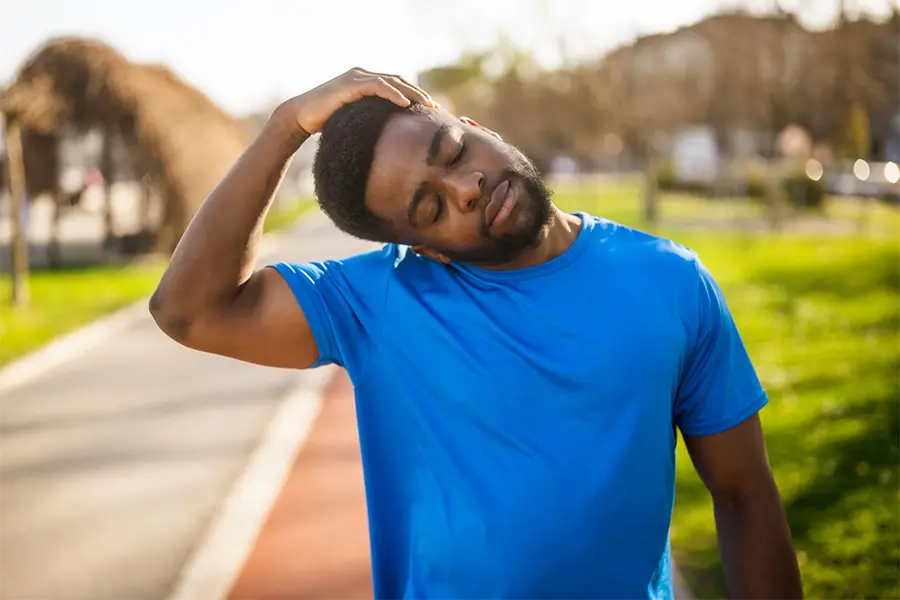 male doing neck stretches outside