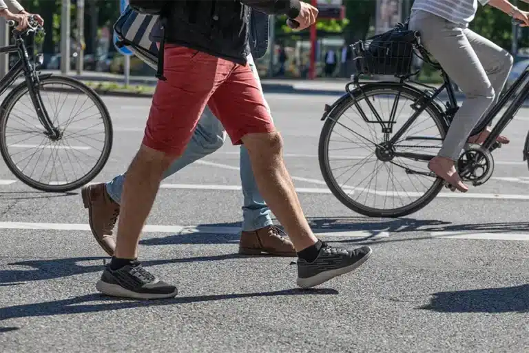 pedestrian walking with bikers in the background