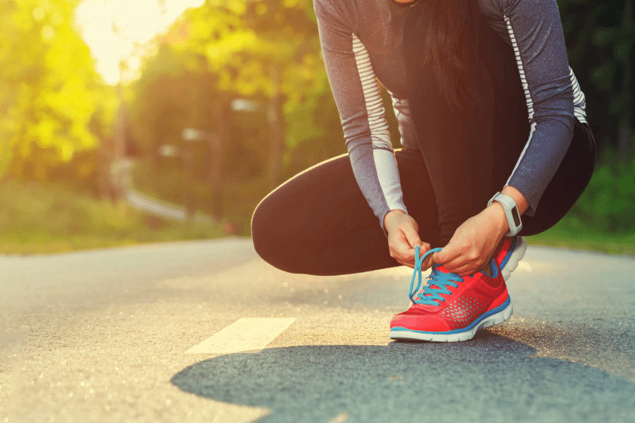 female runner tying her shoes preparing for a jog