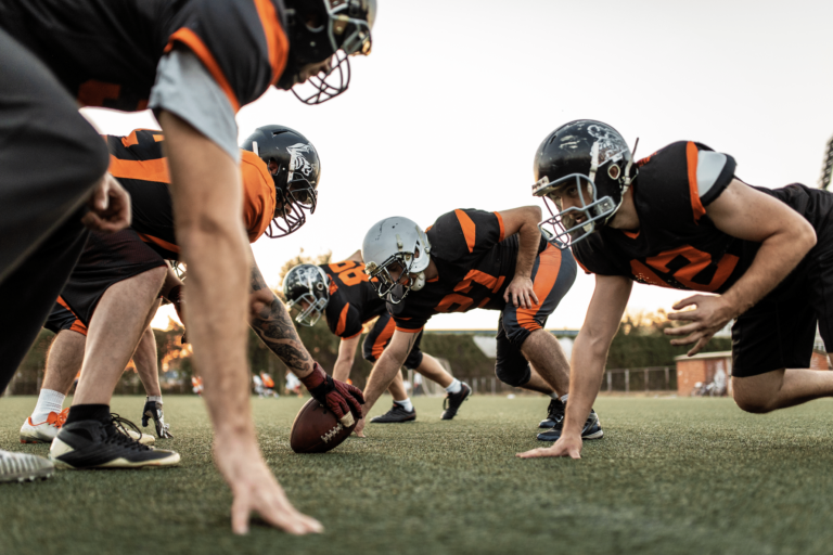 football players getting ready to start a play