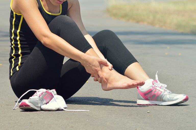Woman gripping her ankle in pain