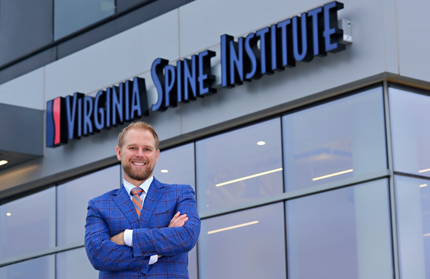 Man smiling in front of Virginia Spine Institute signage