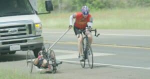 Aaron supporting a paralyzed hand cyclist.