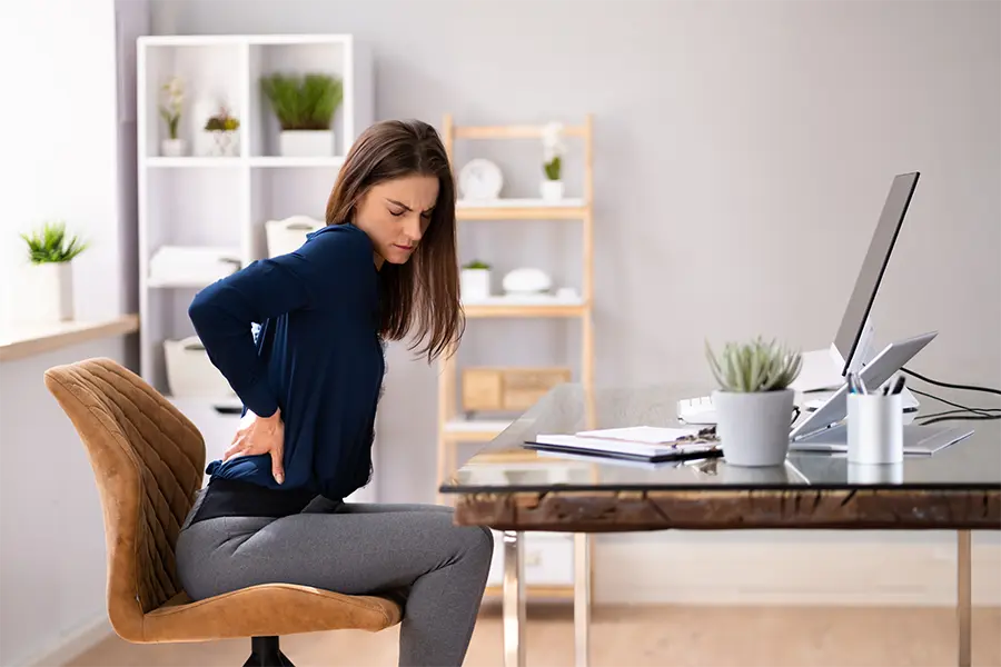 woman with back pain on home office chair